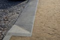 Contrast between gray basalt paving for cars and soft gravel road for pedestrians made of beige sandy material. the transition con