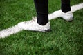 Detail of football soccer player on white line on soccer football field with artificial grass