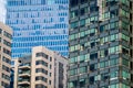 Contrasting architecture with an old building flanked by modern glass high-rises under blue sky Royalty Free Stock Photo