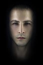 Contrasting male portrait on black background. Light and shadow on the man`s face. Stylish, brutal man, art photo. Silhouette face