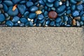 Contrast textures of a paved driveway and pebbled sidewalk. Background image.