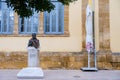 Contrasting view of the bust of Ourania Kokkinou next to an umbrella in front of Faneromeni School, Nicosia old city Royalty Free Stock Photo