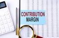 CONTRIBUTION MARGIN on sticker on chart background, business concept