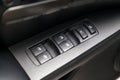 The control buttons for opening and closing windows of doors and electric controls on the door in gray with upholstery in a luxury
