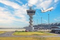 Control tower at a passenger airport against the background of an airplane taking off into the sky. Royalty Free Stock Photo