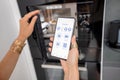 Controlling smart devices with phone on the kitchen Royalty Free Stock Photo