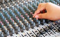 Controls of audio mixing console with hand Royalty Free Stock Photo