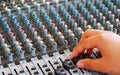 Controls of audio mixing console with hand Royalty Free Stock Photo