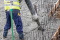 Contruction worker pouring concrete, directing the pump tube