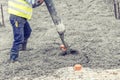 Contruction worker pouring concrete, directing the pump and working in foundation