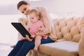 Emotional babysitter showing modern device to a child and smiling Royalty Free Stock Photo