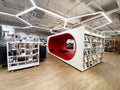 Convenient modern library with a comfortable red sofa for reading