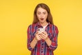 Convenient online app. Portrait of amazed ginger girl using mobile phone and looking shocked pleasantly surprised by mobile Royalty Free Stock Photo