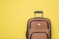 A convenient travel suitcase on a yellow background. Flat lay
