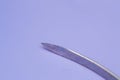 Conventional cutting needle used in surgery on blue background