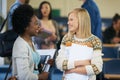 Conversation, university and women students in classroom with text books and documents for information. Smile Royalty Free Stock Photo