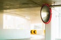 Convex safety mirror at curve of indoor car parking lot to reduce risk of accidents from blind corner or blind spots. Convex