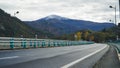 Journey to the Holy: Lourdes Highway Beneath Snowy Pyrenean Peaks.