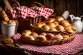Convey the warmth of a cozy setting with a wicker basket filled with buns placed under a red and white checkered tablecloth. Royalty Free Stock Photo