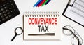 Conveyance tax- text on the notebook with a pen and office tools