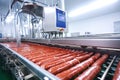Photo of a conveyor belt filled with hot dogs. industrial production of sausage and meat in a modern plant. Smoking of sausages