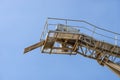 Conveyor belt for gravel against the blue sky at an industrial cement plant. Royalty Free Stock Photo