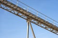 Conveyor belt for gravel against the blue sky at an industrial cement plant. Royalty Free Stock Photo