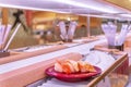Conveyor belt sushi carrying a plate of three pieces of salmon sushi.