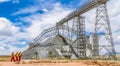 Conveyor belt transporting Platinum ore for processing with mining safety inspectors checking for damage