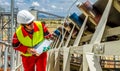 Conveyor belt transporting Platinum ore for processing with mining safety inspectors checking for damage