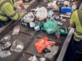 People working on a conveyor belt in a waste management plant