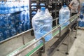 Conveyor line or belt with clean pure drinking water in plastic bottles packed in cellophane, loading finished goods at Royalty Free Stock Photo