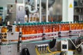 Conveyor line with plastic bottles of juice at modern factory equipment. Beverage manufacturing plant interior inside