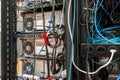 Convoluted mess of power sockets and tangled electrical cables tied together with zip ties hanging in a rack of electronic Royalty Free Stock Photo