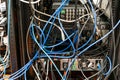 Convoluted mess of power sockets and tangled electrical cables tied together with zip ties hanging in a rack of electronic Royalty Free Stock Photo