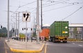 Convoy of big rig semi trucks transporting containers running on the city street with tram line Royalty Free Stock Photo