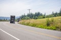 Convoy of big rigs semi trucks with semi trailert going on the turning road with hills Royalty Free Stock Photo