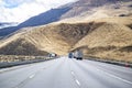 Convoy of the big rigs semi trucks transporting cargo in different semi trailer running on the wide mountain winding multiline