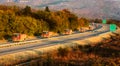 Convoy or caravan of red utility trucks on a highway