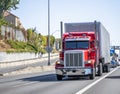 Convoy of classic big rigs semi trucks with semi trailers transporting cargo running in the line on the highway road Royalty Free Stock Photo