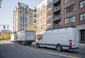 Convoy of different trucks with box trailers and long compact mini van