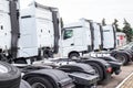 A convoy of truck tractors stands at a service parking lot. Truck service concept, industry, background