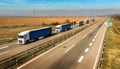 Convoy of White and Blue transportation trucks in line on a countryside highway