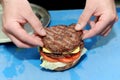 Cook adding burger on prepared buns for hamburger. Preparing and making hamburger. Royalty Free Stock Photo