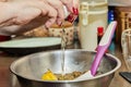 The cook adds an egg to the bowl of ingredients to prepare the dish