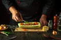 The cook adds green parsley to the zucchini. The concept of cooking a national stuffed squash boat or marrow in a restaurant Royalty Free Stock Photo