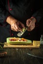 The cook adds onions to the marrow. The concept of cooking national stuffed squash or zucchini in the restaurant kitchen. Free Royalty Free Stock Photo