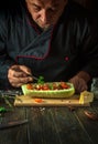 The cook adds parsley to stuffed squash on the kitchen table. The concept of preparing a national stuffed zucchini or marrow for Royalty Free Stock Photo