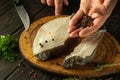 The cook adds pepper to Anarhichas fish steaks on the kitchen table. The concept of preparing a delicious fish dish with spices Royalty Free Stock Photo