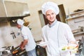 Cook chef with food in restaurant kitchen Royalty Free Stock Photo